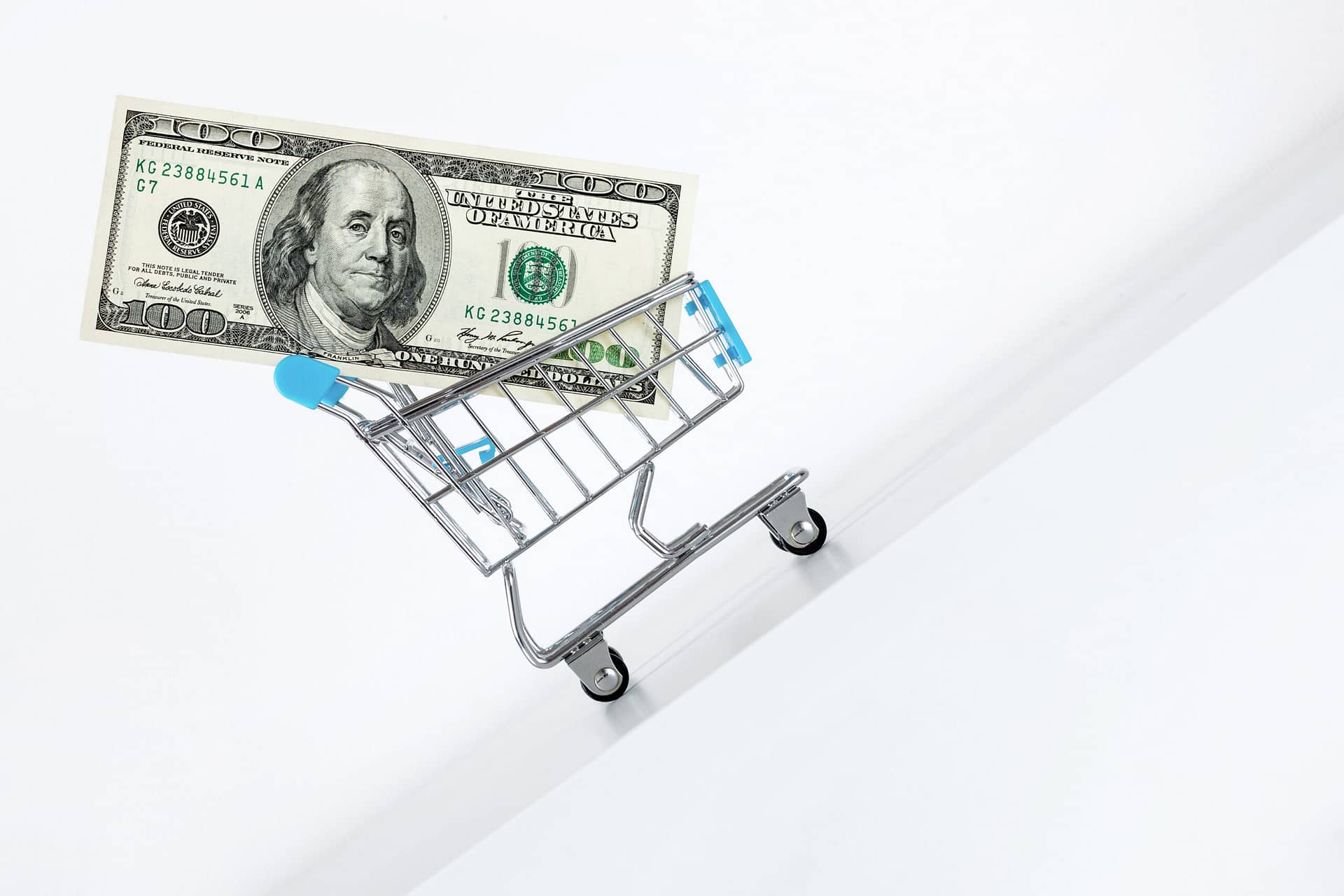Hundred dollar bill in cart. Rising up direction with red arrow